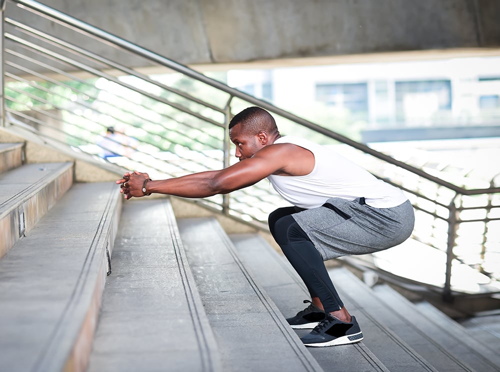 Male athlete performing stair jumps.