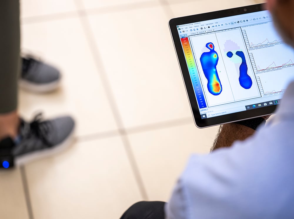 Clinician reviewing plantar pressure data captured using XSENSOR's Intelligent Insoles being worn on a patient. Clinician reviewing plantar pressure data captured using XSENSOR's Intelligent Insoles being worn on a patient.