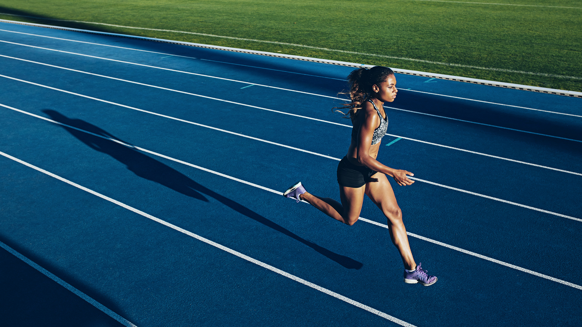 Athlete running on an outdoor track.