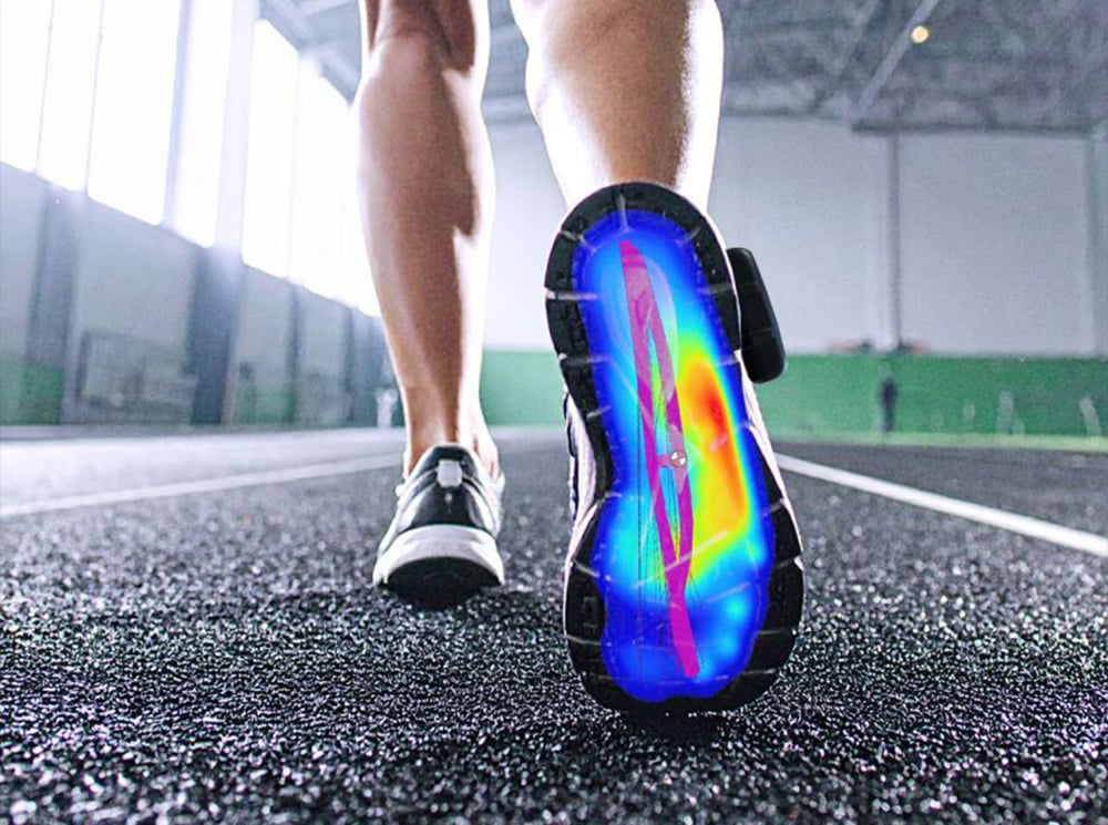 A rear shot of lower legs and we see the plantar surface of a running shoe with a pressure map. A rear shot of lower legs and we see the plantar surface of a running shoe with a pressure map.