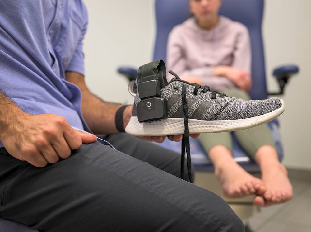 XSENSOR's Intelligent Insoles inside the shoes of a patient with the patient in the background.